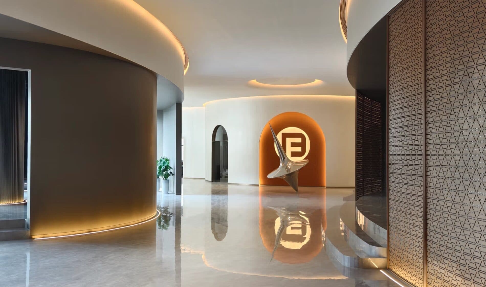 The reception hall of Fadior's Foshan experience centre, with the brand mark set into a curved stone wall