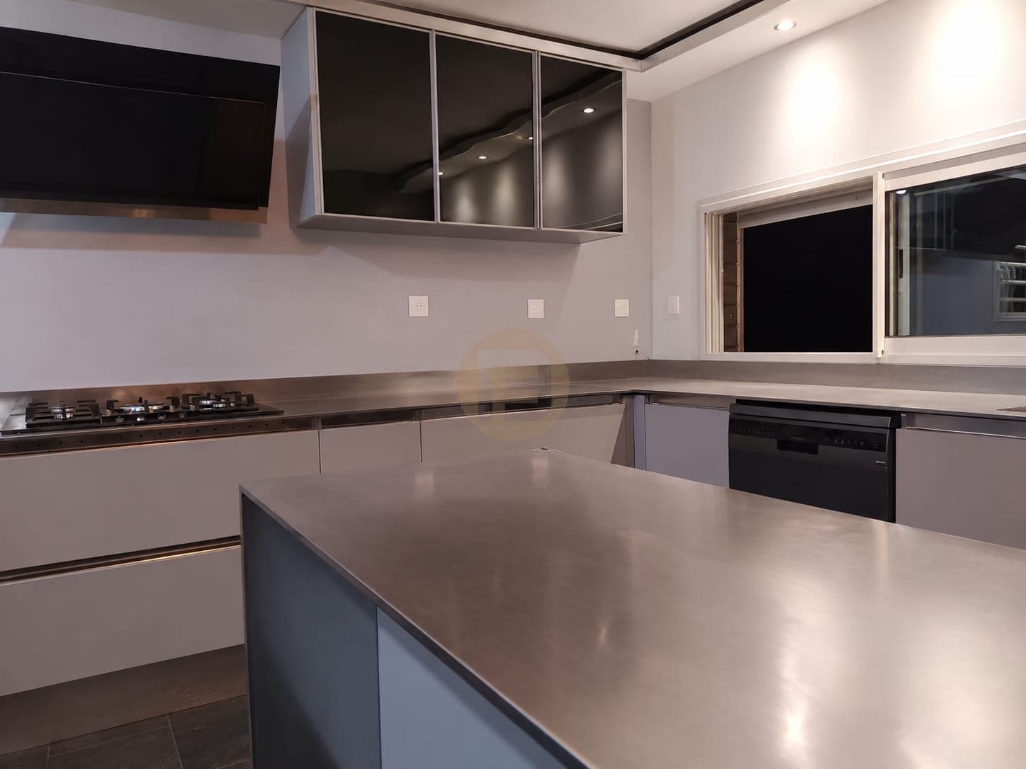 Wide view of the blue island and surrounding kitchen runs