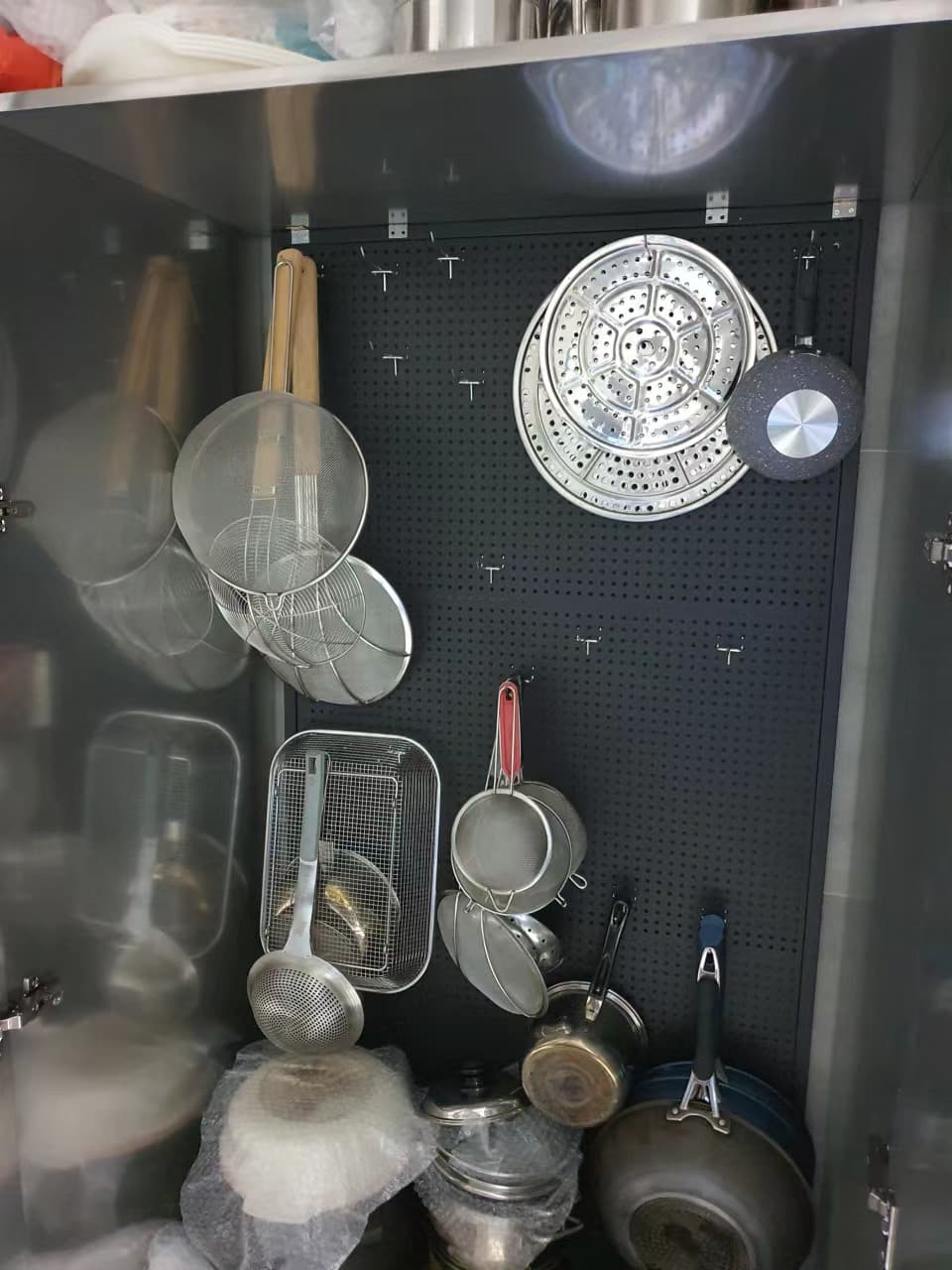 Open storage bay with pots and utensils in the same kitchen