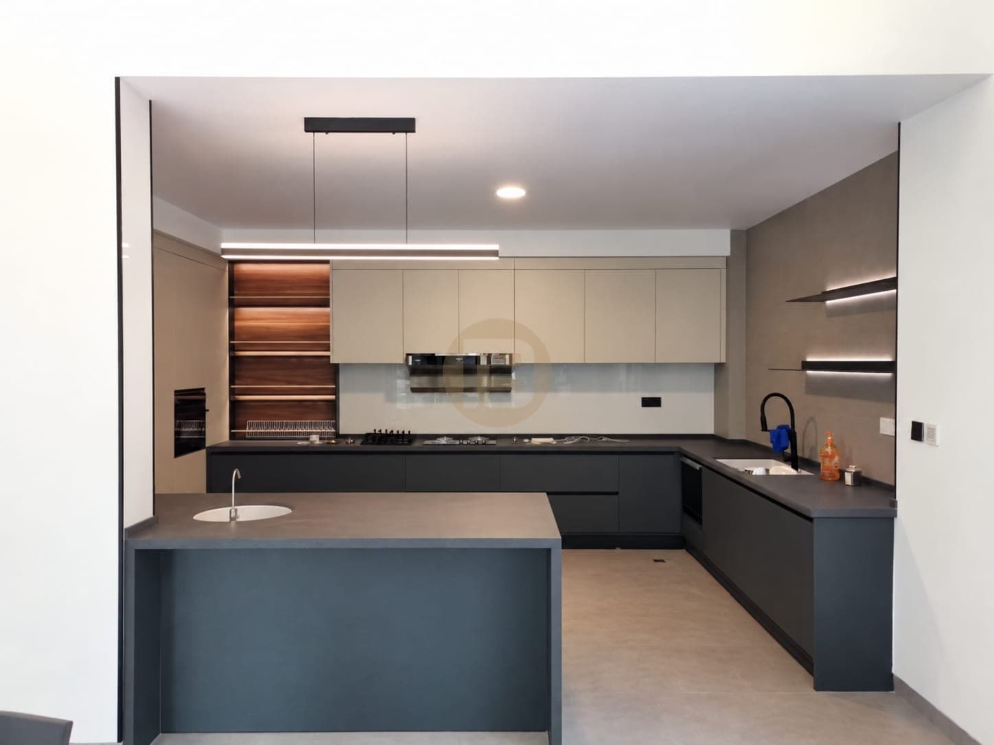 Two-tone kitchen with cream wall cabinets, charcoal base units, a peninsula sink and walnut-look shelving