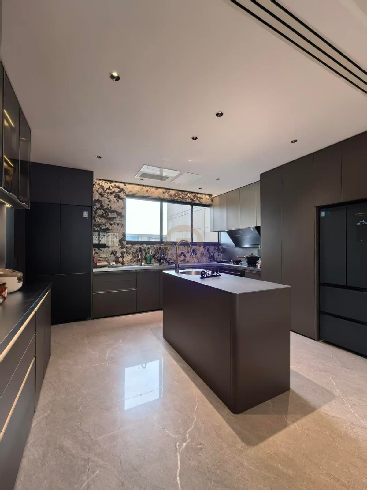 Cocina oscura amplia con isla central, pared del fregadero y armarios altos