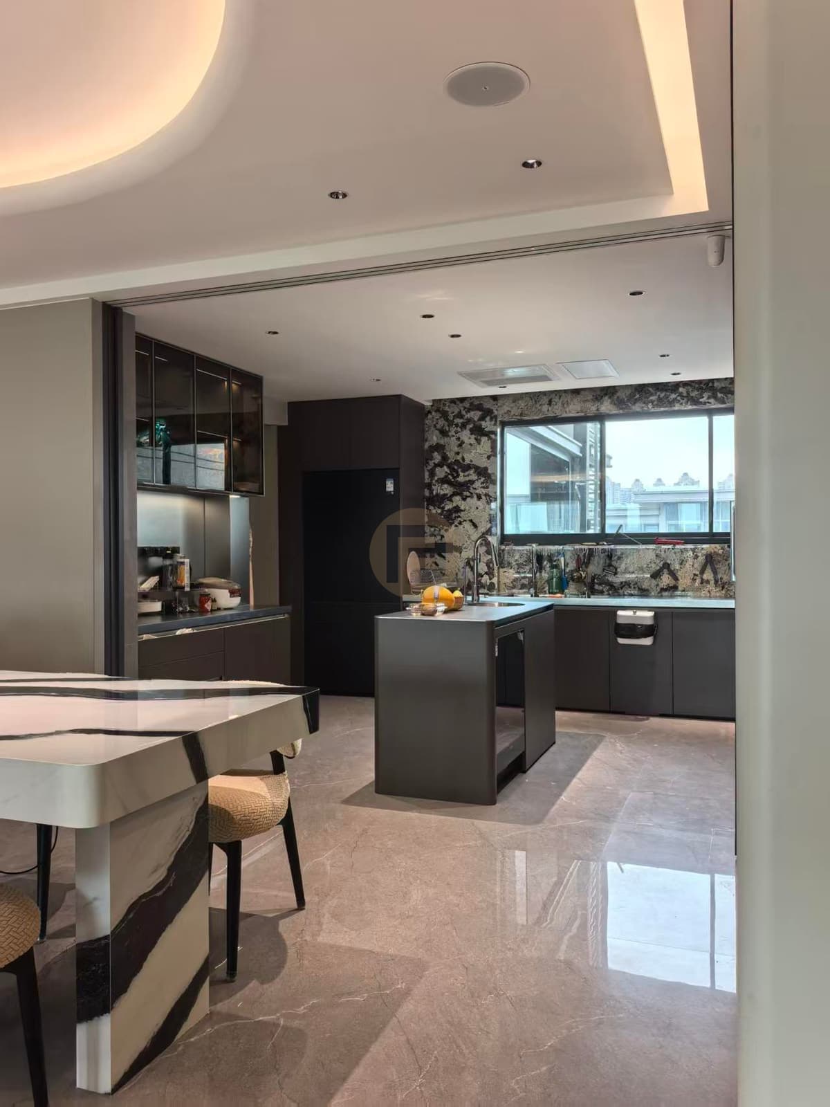 Cocina oscura e isla vistas desde el comedor contiguo