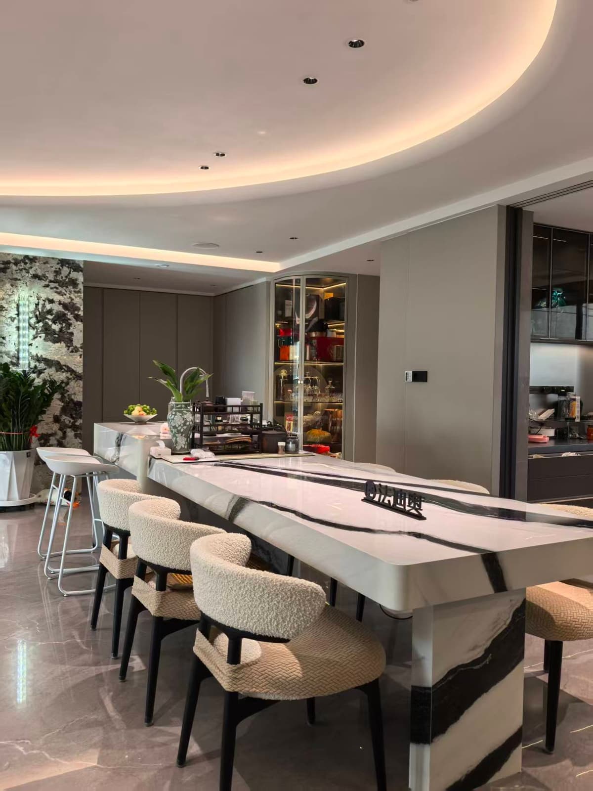 Comedor, isla y vitrina curva del recibidor en una misma vista