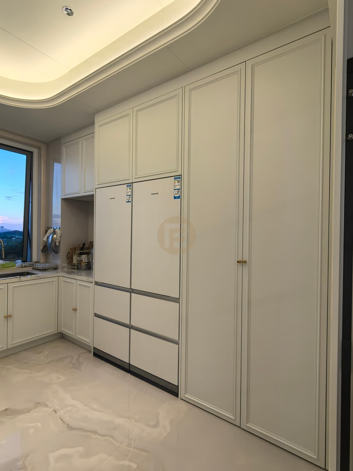 Armarios altos blancos de cocina junto al frigorífico