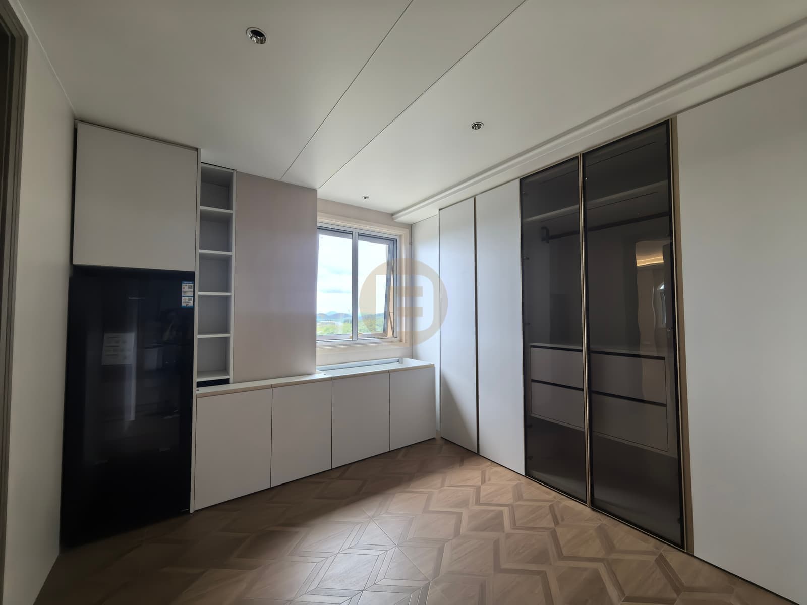 Armarios blancos y de cristal a medida junto a una ventana