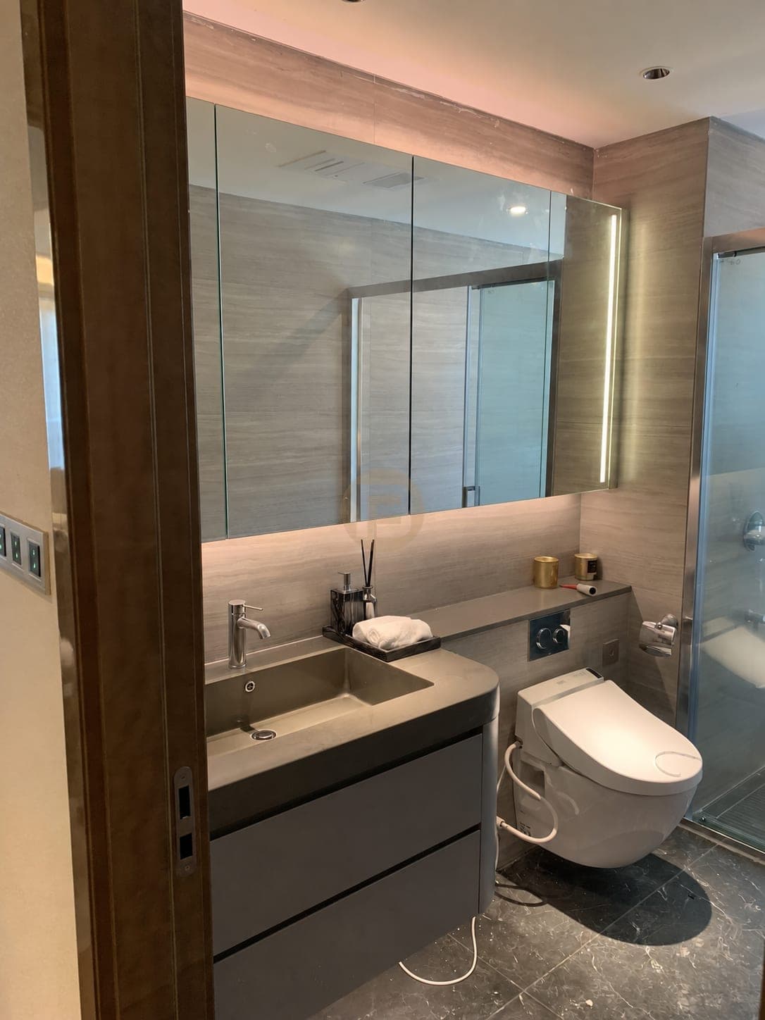 Grey fitted bathroom vanity photographed from the doorway