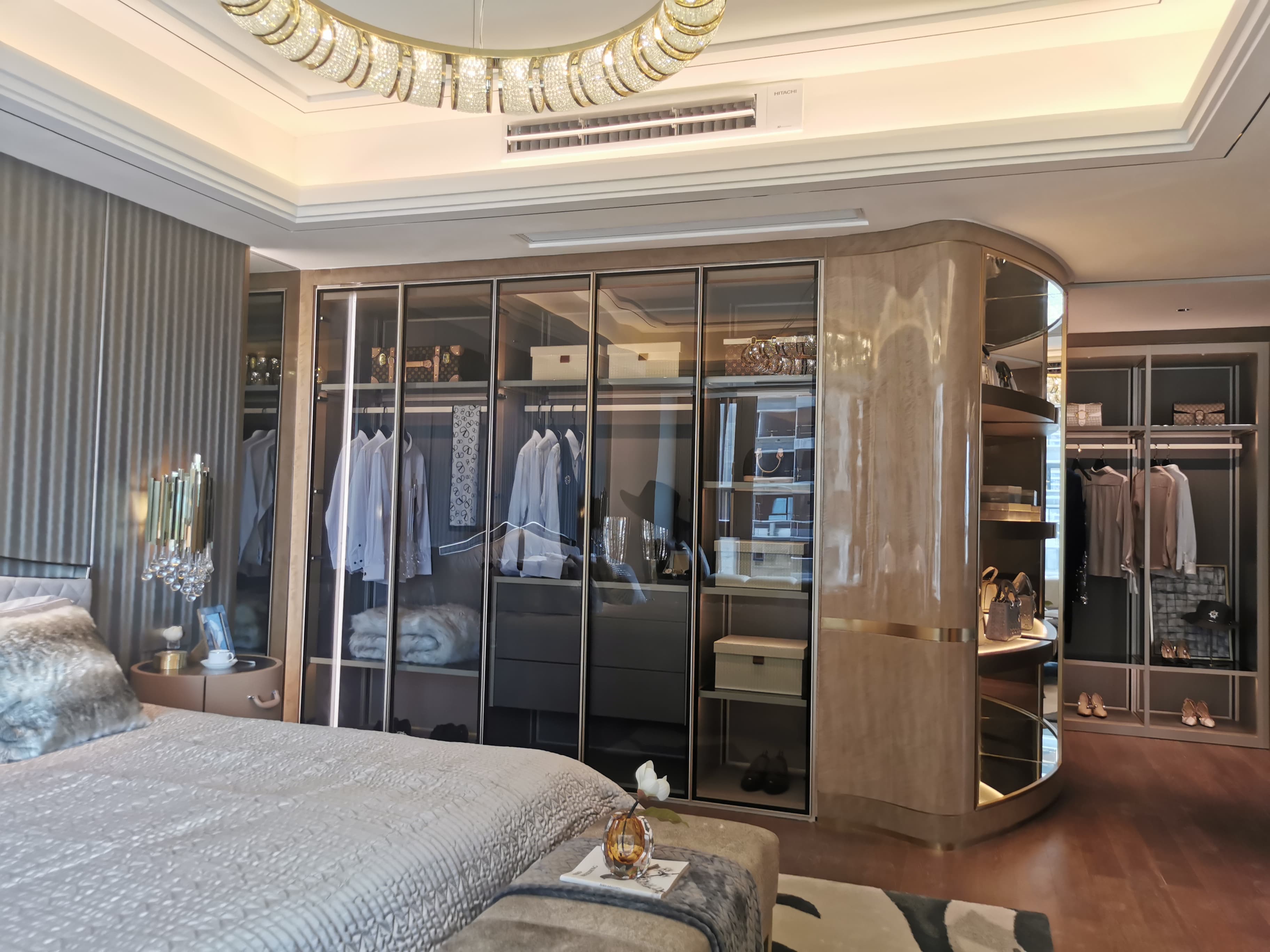 Bedroom-wide view of dark glass wardrobe and curved dressing-area transition