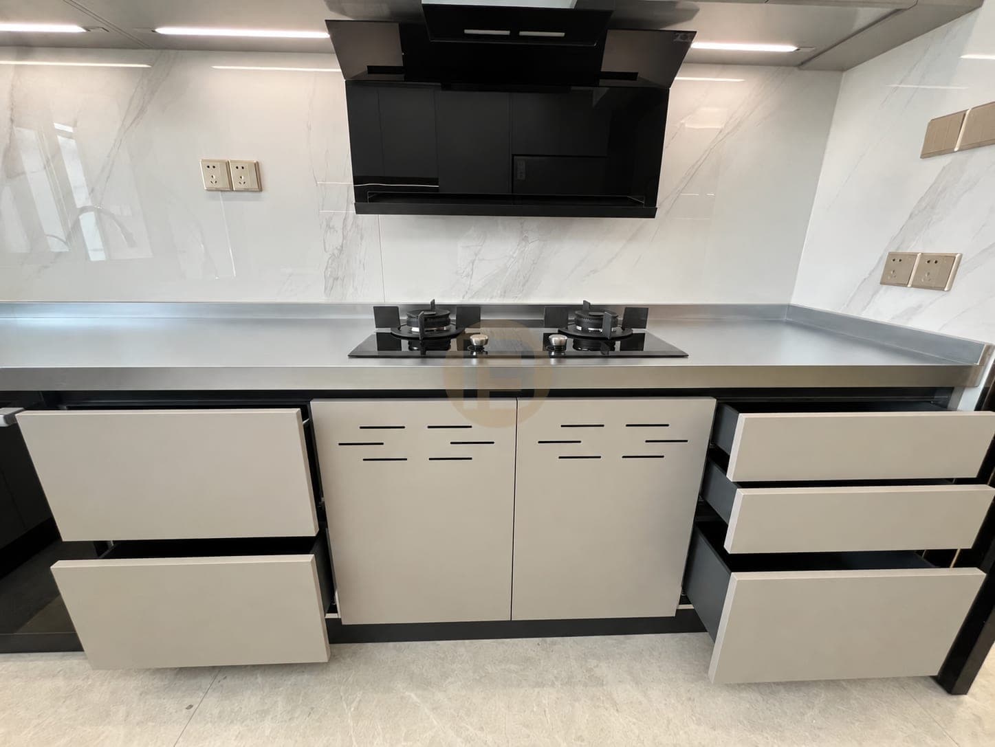 Hob run with a stainless steel worktop and vented taupe base doors, drawers open