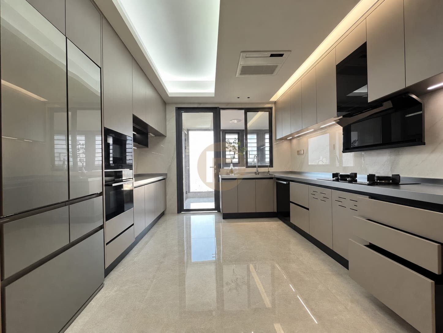 Two-run galley kitchen with grey glass tall units, taupe base cabinets and a balcony door