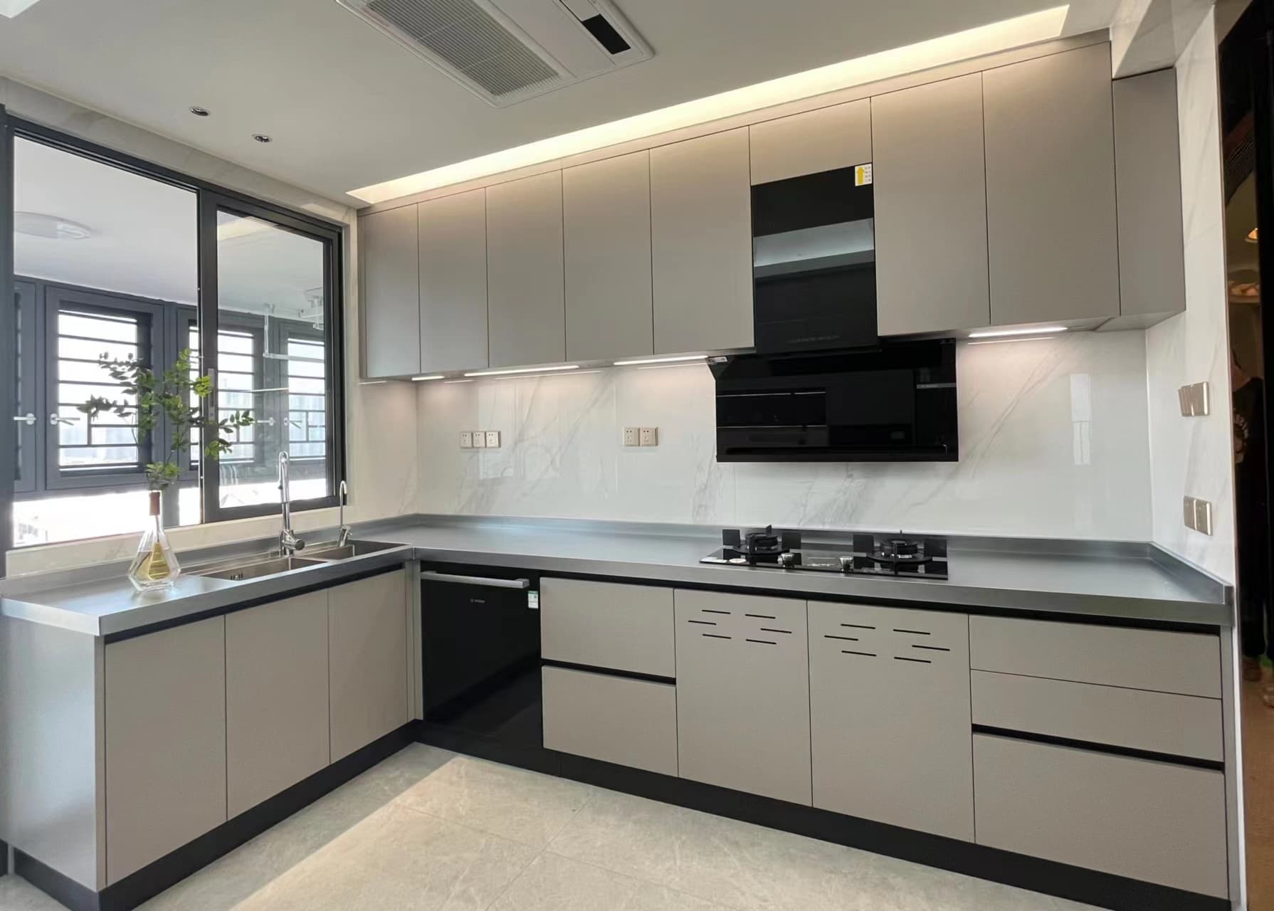 Window-side sink return and hob run with pale grey cabinets