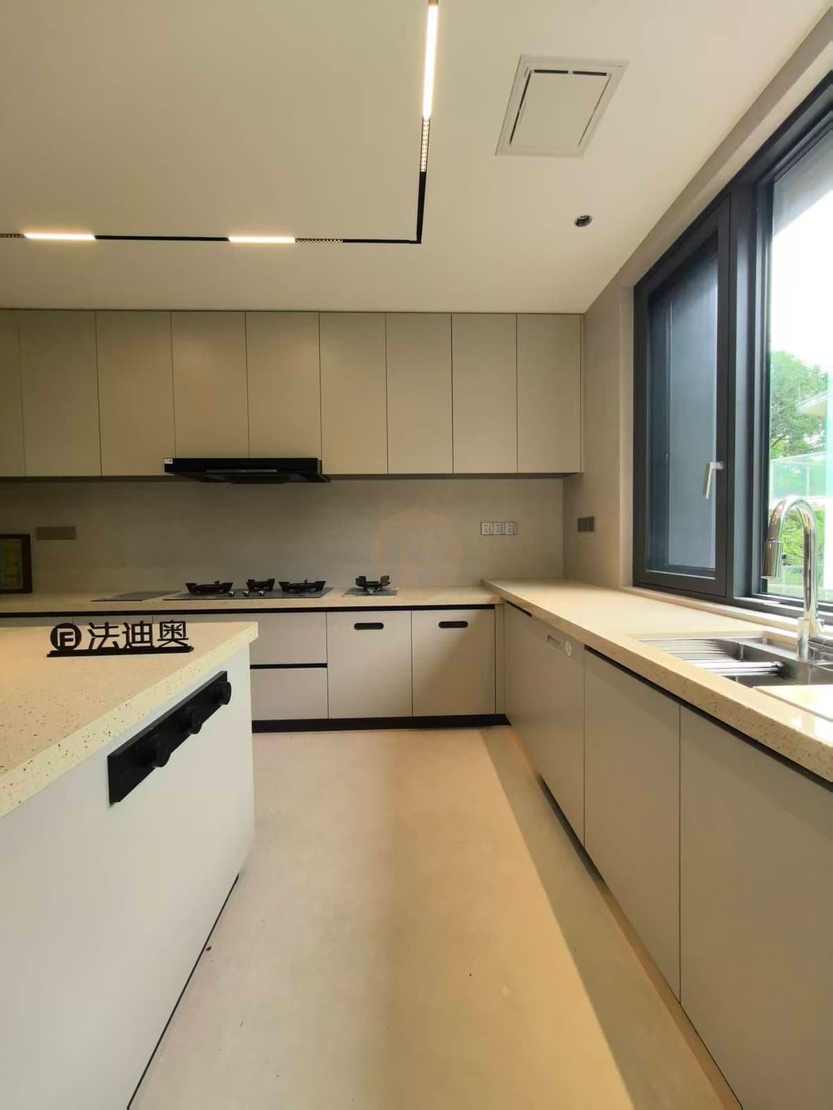 Light-toned kitchen island and cabinets beside the window