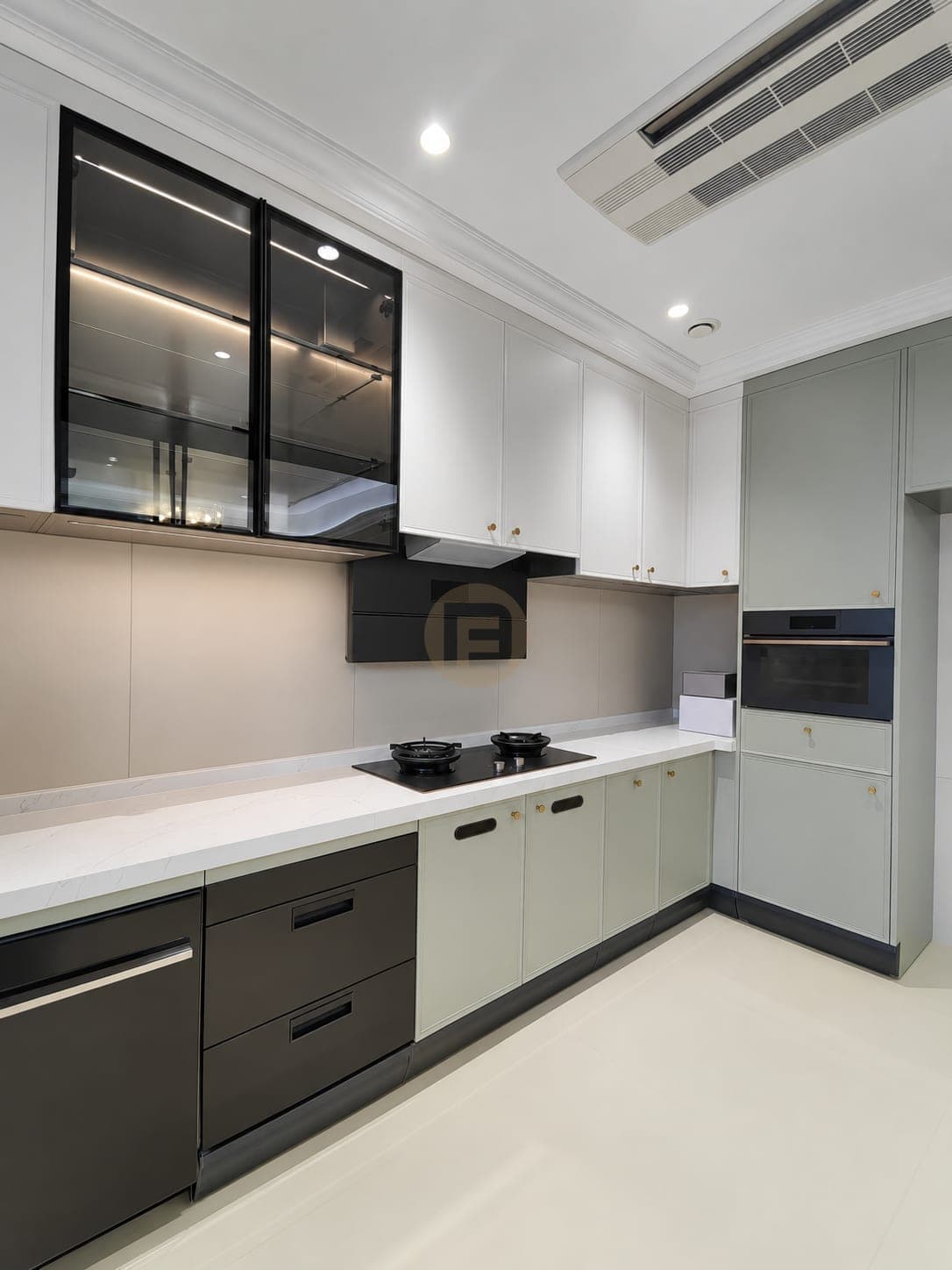 Pale green and white fitted kitchen with tall oven cabinets
