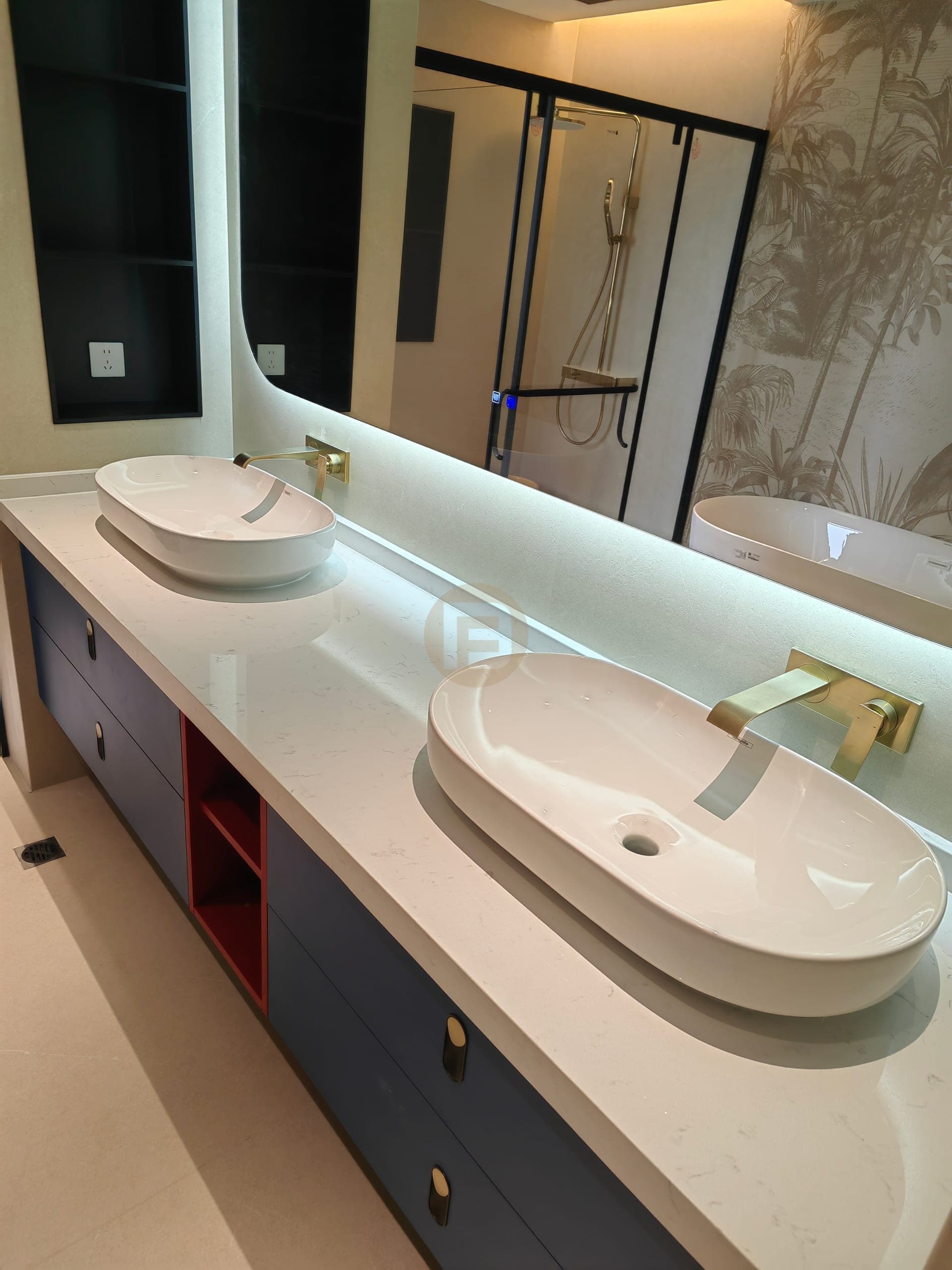 Angled view of the navy double vanity, two basins and red open storage niches