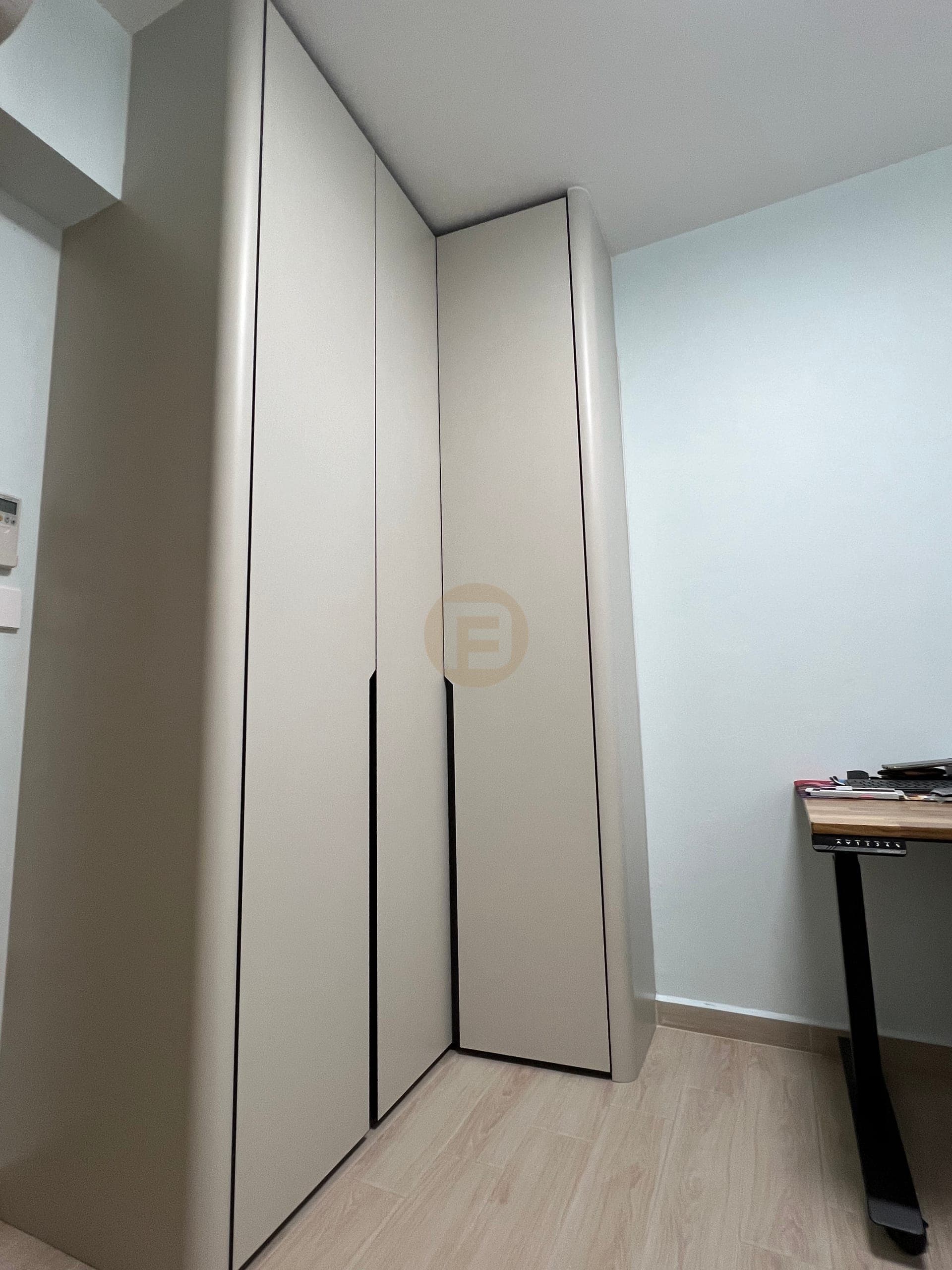 Corner fitted wardrobe beside a separate height-adjustable desk