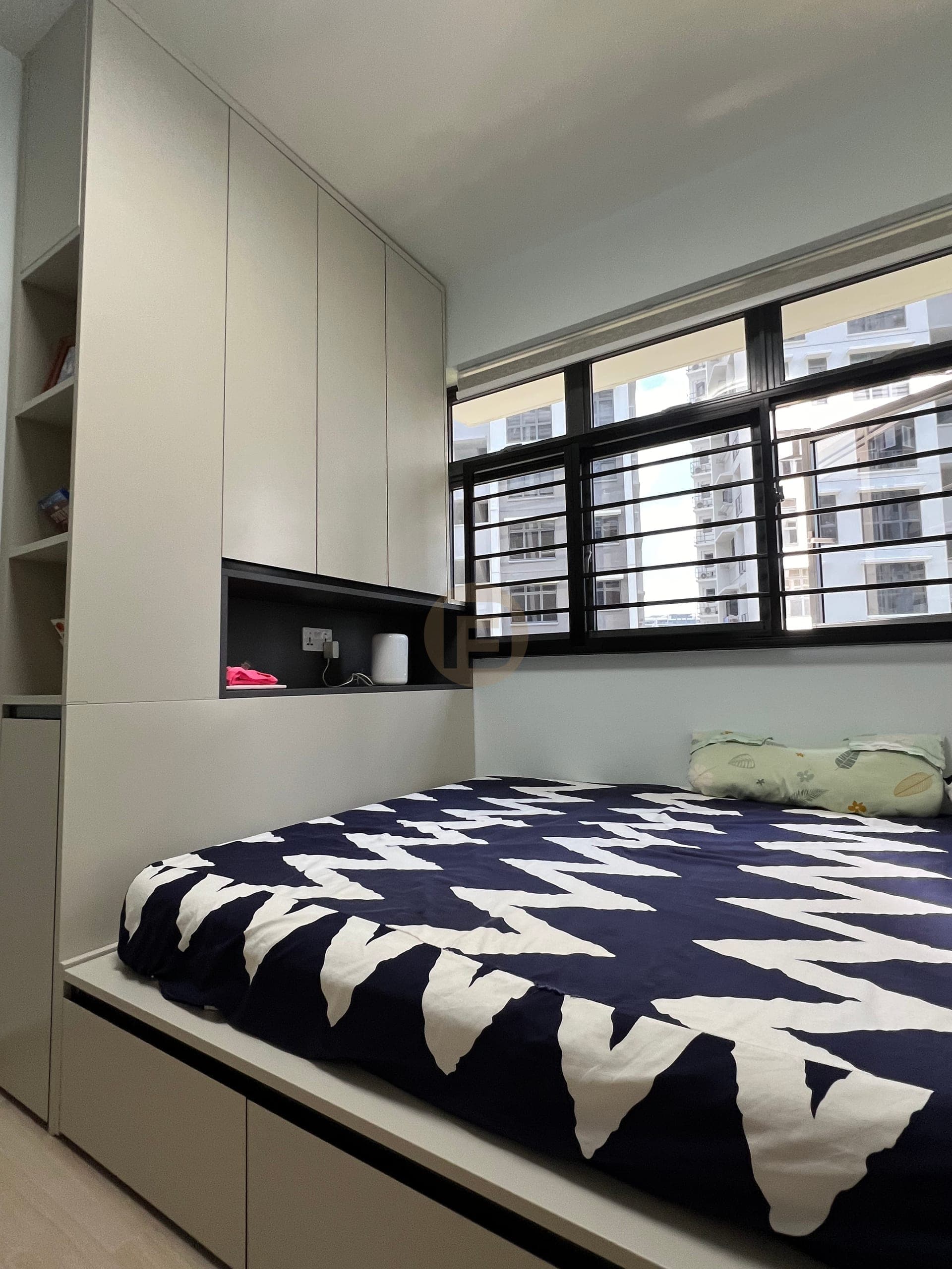Platform storage bed with overhead cabinets in a compact bedroom