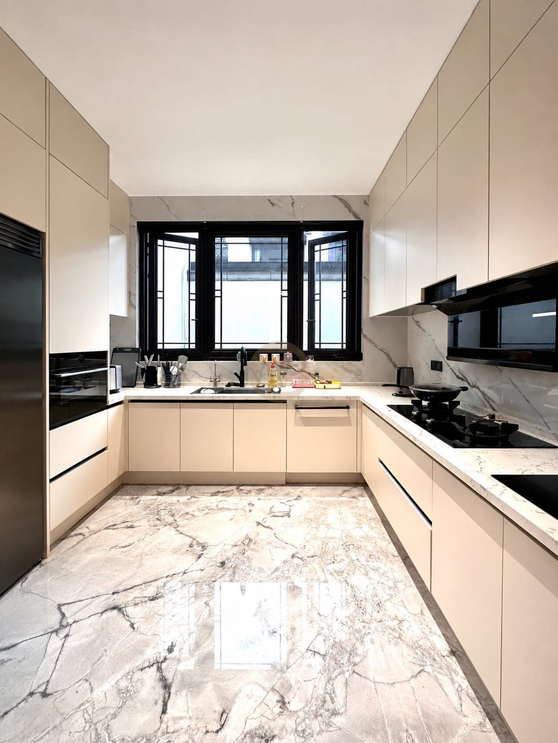 Cocina crema en U con ventana de marco negro y columna de electrodomésticos