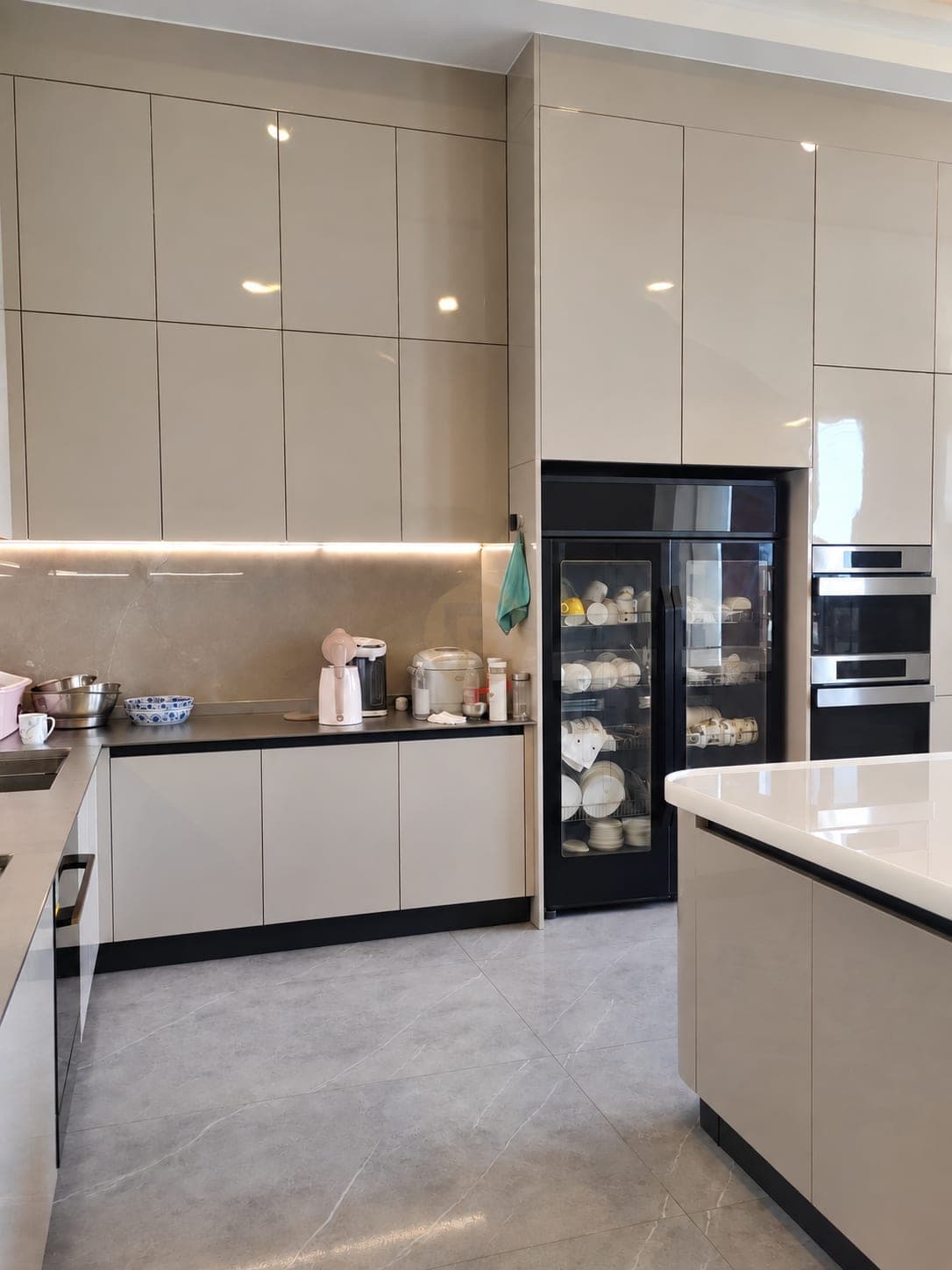 Tall storage wall with ovens and a glazed crockery cabinet
