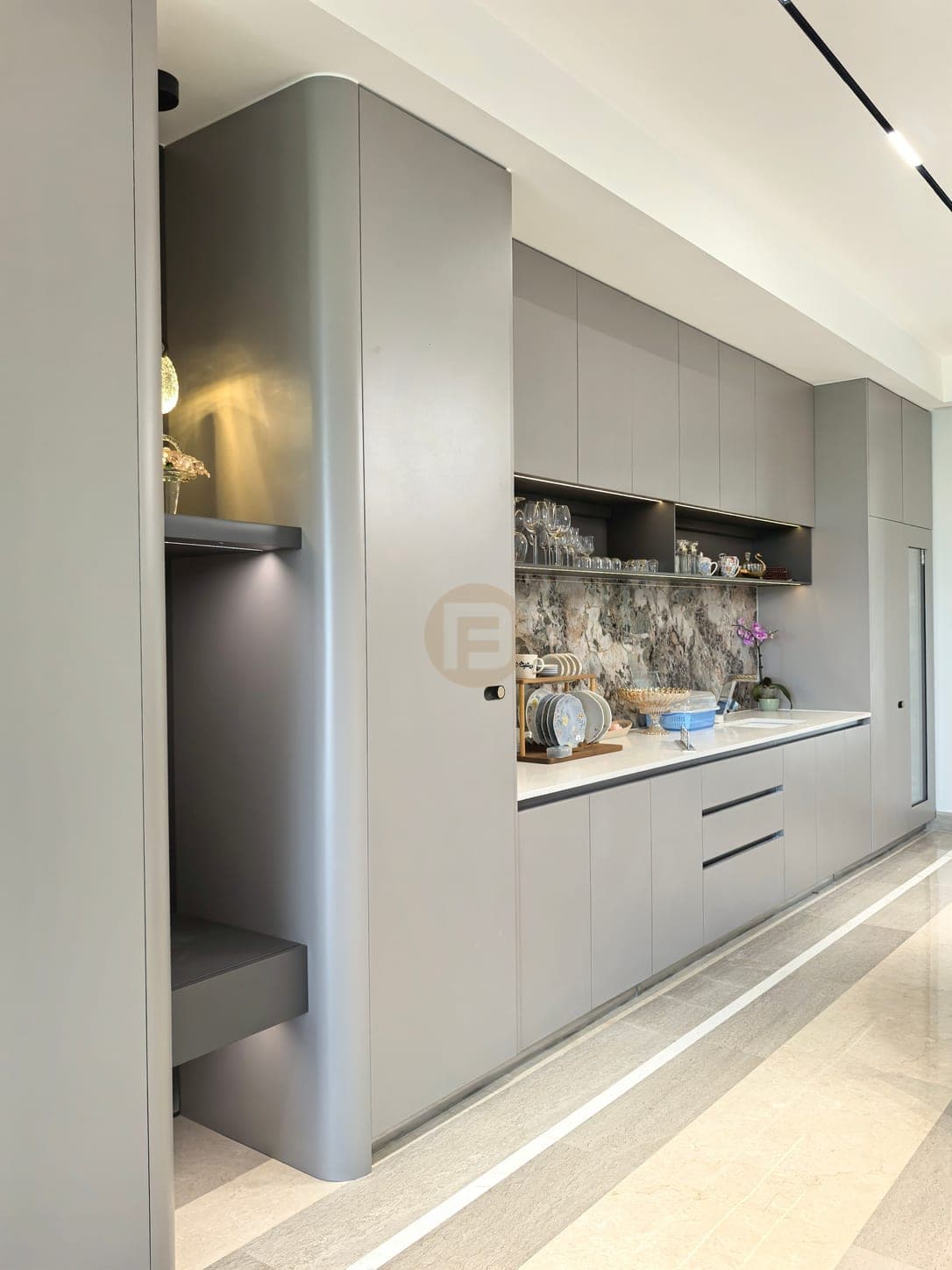 Grey dining-side cabinet wall and sink counter viewed from the opposite end with appliance doors closed